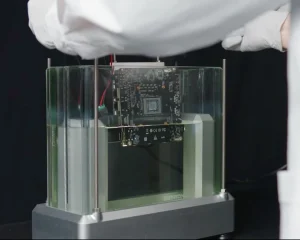 Это не вода окружает материнскую плату. Это маслянистая жидкость, которая охлаждает технику во время работы гоночного симулятора (не показан). Система искусственного интеллекта разработала этот состав, чтобы он был более экологичным, чем существующие варианты.MICROSOFT