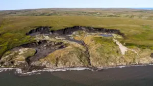 Арктическая вечная мерзлота содержит колоссальные запасы органического углерода. При таянии грунта или разрушении береговой линии этот углерод попадает в океан, где микроорганизмы разлагают его, превращая в парниковые газы, наносящие ущерб климату. Изображение предоставлено Alfred-Wegener-Institut / Jaroslav Obu